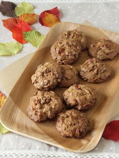 chocolate chip cookies on a wooden plate with autumn leaves