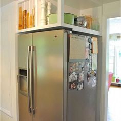 a stainless steel refrigerator with magnets and pictures on the door, in a kitchen