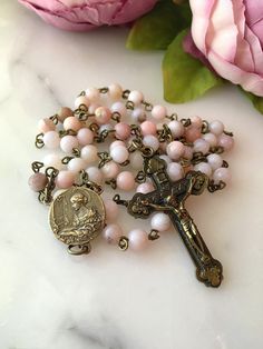 "Handmade 6mm Natural Pink Opal Gemstone St. Cecilia bronze women's Rosary. The vintage style St. Cecilia center features a harp on the back and measures 5/8\" in diameter. The traditional style bronze crucifix is made in Italy. St. Cecilia is the patron saint of singers, musicians and the arts. *The holy card is not included." Vintage Bronze Rosary As Gift, Vintage Rosary With Round Beads As Gift, Antique 8mm Beads For Jewelry Making, Vintage Adjustable Rosary With Round Beads, Vintage Adjustable Rosary, St Cecilia, Rosary Beads Catholic, Catholic Rosary, Rosary Catholic