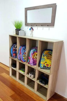 a wooden shelf filled with school supplies on top of a hard wood floor next to a mirror