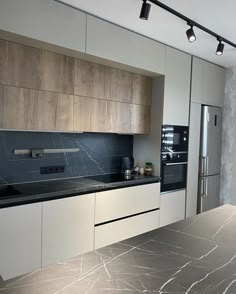 a modern kitchen with marble counter tops and stainless steel appliances