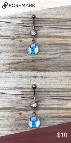 two dangling belly rings with blue and white images on them