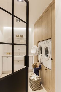 a young boy is playing with the laundry machine in his home washer and dryer