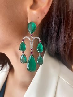 Discover the allure of our Green Emerald Ruby Silver Diamond Chandelier Earrings. These stunning earrings feature a captivating combination of emerald and ruby stones set in silver, adorned with sparkling diamonds. Perfect for adding a touch of elegance to any outfit. Luxury Green Sterling Silver Bridal Earrings, Luxury Green Dangle Chandelier Earrings, Green Diamond Chandelier Drop Earrings, Elegant Green Gemstone Chandelier Earrings, Elegant Green Ruby Jewelry, Elegant Green Emerald Chandelier Earrings, Green Gemstone Accented Earrings For Party, Green Gemstone Accent Earrings For Party, Emerald Diamond Earrings