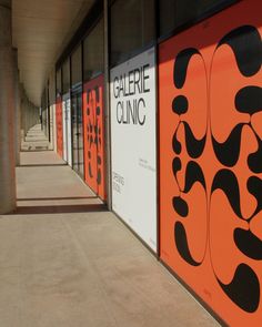 an orange and black wall next to a building with several different designs on the walls