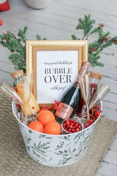 a basket filled with champagne, oranges and other holiday items next to a sign that says bubble over