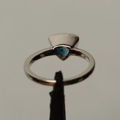 It is a real London blue topaz ring. The main stone is 8 mm*8mm triangular. The basic metal is sterling silver and plated with rhodium. To change the metal to a solid gold (white/rose) or platinum is also available, please ask for a quotation if you want. You can also go to my shop Home for more elegant rings: https://www.etsy.com/shop/godjewelry?ref=hdr_shop_menu Topaz is November birthstone. More topaz rings: https://www.etsy.com/shop/godjewelry?ref=hdr_shop_menu&section_id=20715039 Custom Trillion Cut Sapphire Anniversary Ring, Silver Trillion Cut Sapphire Ring, Silver Sapphire Trillion Cut Promise Ring, Silver Trillion Cut Sapphire Promise Ring, Blue Topaz Ring With Bezel Setting For Promise, Modern Blue Topaz Jewelry With Bezel Setting, Modern White Gold Trillion Cut Ring, Silver Trillion-cut Solitaire Jewelry, Silver Trillion Cut Solitaire Jewelry