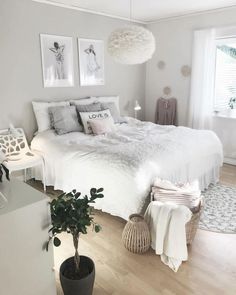 a bedroom with white walls and wood flooring is decorated in shades of light gray