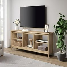 a living room with a large flat screen tv on top of a wooden entertainment center