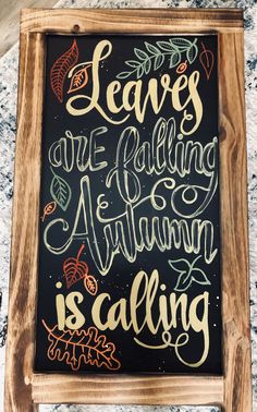 a chalkboard sign with the words leaves are falling autumn is calling written on it