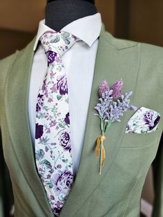 a man wearing a suit and tie with flowers on the lapel flower brooch