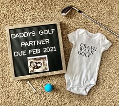 a baby's golf outfit next to a sign that says daddys golf partner due feb 21, 2011