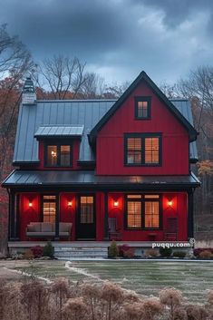 a red house is lit up at night with lights on the front and side windows