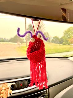 a car dashboard with a stuffed animal hanging from the dash board