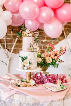 a wedding cake with pink flowers and balloons in the background at a bridal party