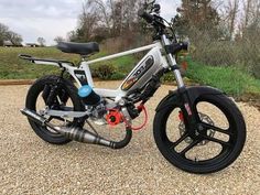 a white and black bike parked on top of gravel