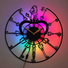 a clock that is lit up with the colors of the rainbow and has flowers on it