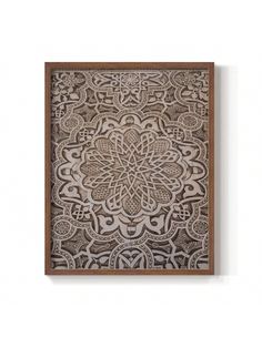 an intricate wooden wall hanging on the wall with a white and brown pattern in it