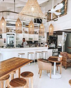 an instagram photo of a restaurant with chairs and tables in the center, along with hanging lights