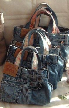 three denim purses sitting on top of a couch