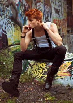 a man sitting on top of a bench next to graffiti