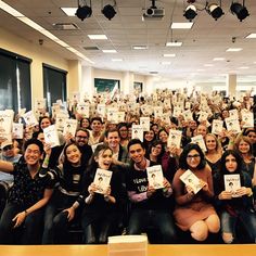 a large group of people holding up books