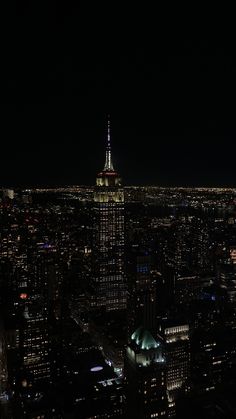 an aerial view of the city at night with lights on and buildings lit up in the dark