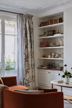 a living room filled with furniture next to a window