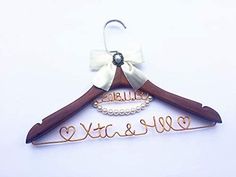 a wooden hanger with a white bow on it that says, bride and me