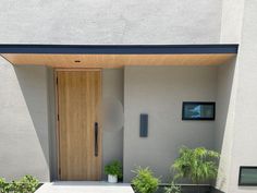 an entrance to a house with plants and potted plants