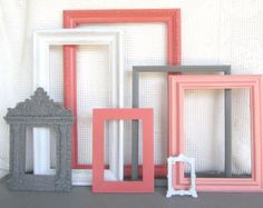 four different colored frames sitting next to each other on top of a table in front of a white wall