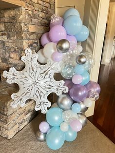 balloons and snowflakes are arranged in front of a fireplace