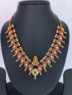 Goddess Lakshmi Red Kemp Kundan Mango Necklace with Matching JhumkiColor : GoldenSize : Necklace Length : 16 Inches; Earring Length : 1.25 InchesStones : Red Stone Kundan Green Stone Red Chandbali Temple Necklace With Stone Work, Festive Red Kundan Necklace With Latkans, Red Necklaces With Latkans For Diwali, Red Temple Necklace With Latkans For Wedding, Red Temple Necklace For Diwali Celebration, Bollywood Style Red Temple Necklace For Celebrations, Red Bollywood Temple Necklace For Celebration, Festive Red Necklace With Latkans, Red Necklace With Latkans For Puja