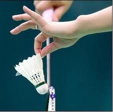 a person holding a badminton racket with two shuttles attached to it