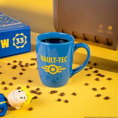 a blue coffee mug sitting on top of a yellow table next to some chocolate chips