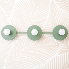 three green and white circular lights on a wall