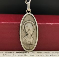 A beautiful genuine 1950s vintage solid silver Virgin Mary pendant in Art Deco style, floats from a  17-inch long 925 silver necklace. In good condition, would make a nice gift for someone special! Material: silver, hallmarked Pendant measures: 15 x 33 mm total weight (with chain): 6.5g Box on photos is NOT included! A stunning religious jewelry shop well worth a visit ... https://www.etsy.com/shop/SacredMagic Vintage Necklaces Stamped 925, Antique Silver Necklace With Polished Finish, Vintage Necklace With Polished Finish For Gift, Silver Oval Pendant Necklace For Commemoration, Silver Vintage Charm Jewelry For Commemoration, Silver Vintage Charm Necklace For Memorial, Vintage Silver Necklaces For Memorial, Silver Jewelry With Vintage Charm For Commemoration, Silver Necklace With Vintage Charm For Memorial