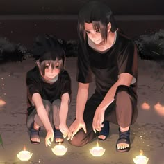 two people sitting on the ground in front of some lit up candles with their hands