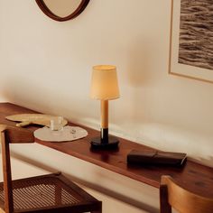 a lamp sitting on top of a wooden table next to a desk with a mirror