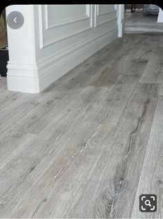 an image of a wood floor with white trim and gray paint on the walls in this room