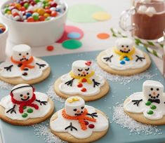 frosted cookies decorated like snowmen on a cooling rack