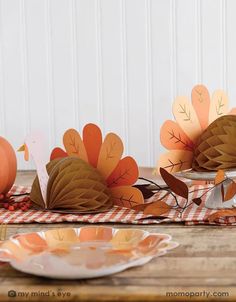 some paper turkeys sitting on top of a wooden table