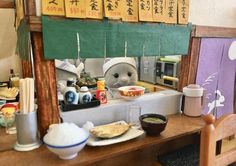 a stuffed animal sitting in front of a counter filled with food