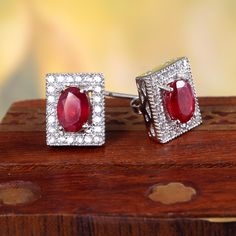 This Sterling Silver Earring features an Elegant Art With Natural Red Ruby Gemstone surrounded by tiny Zircons. The cavity is made from genuine solid 925/92.5 Sterling silver and stamped as S925. This Jewelry is Lead free and finished with Rhodium to resist scratches and tarnish. ITEM DESCRIPTION Item Code: JAER169 Metal: 925/92.5 Sterling Silver Gemstone: Genuine Natural Red Ruby(Fissure filled) Gemstone Shape: Oval Gemstone Size: 5 x 7 MM Earring Length: 11 MM Earring width: 9 MM Weight: 3.56 Smokey Topaz Ring, Rings Vintage Boho, Red Ruby Earrings, Ruby Earrings Studs, Ruby Earrings, Elegant Art, Studs Earrings, Art Deco Earrings, Emerald Earrings