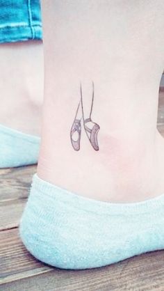 a pair of ballet shoes tattoo on the ankle