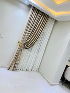 a living room with white walls and curtains