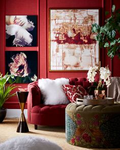 a living room with red walls and pictures on the wall