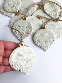 white ceramic ornaments are being held by someone's hand