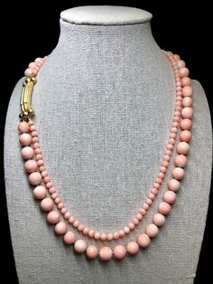 An elegant and unique French-made double strand coral necklace with 18K textured clasp with an open latch box clasp allowing a bit more length by changing position. Wears beautifully and is a welcomed addition to one's own unique collection of fine jewelry. Dimensions/Weight: Necklace measures 18" at shortest strand and weighs a total of 63.8g. Beads are uniformly 8.25mm on the large strand and 4.40mm on the small strand.  Condition: Strands are secure and touchmarks are present and legible. N-T Elegant Double Strand Coral Necklace, Elegant Round Coral Necklace, Elegant Coral Round Necklace, Luxury Coral Jewelry For Formal Occasions, Elegant Coral Necklace With Lobster Clasp, Formal Coral Single Strand Jewelry, Box Clasp, Coral Necklace, Strand Necklace