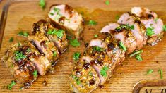 some meat is sitting on a cutting board with green garnish and parsley